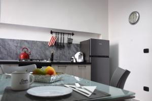 a kitchen with a table with a plate of fruit on it at LYDOY APARTMENT in Reggio di Calabria
