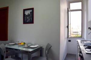 una mesa y sillas en una cocina con ventana en LYDOY APARTMENT, en Reggio Calabria