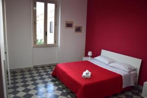 um quarto vermelho com uma cama com um cobertor vermelho em LYDOY APARTMENT em Reggio di Calabria
