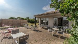 a patio with tables and chairs in front of a building at Hôtel Inn Design La Rochelle in La Rochelle