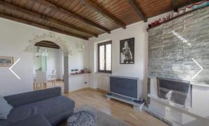 a living room with a couch and a brick wall at Villa Caterina in Perledo