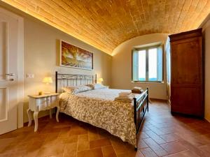 a bedroom with a large bed with a wooden ceiling at Sangi Chianti Vacations in Poggibonsi