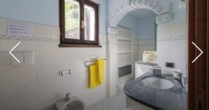 a bathroom with a sink and a yellow towel at Villa Caterina in Perledo +37 photos