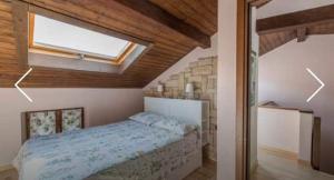 a bedroom with a large bed with a skylight at Villa Caterina in Perledo