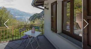 a balcony of a house with a table and chairs at Villa Caterina in Perledo