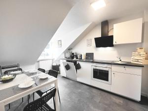 a kitchen with white cabinets and a table and chairs at # VAZ Apartments RS03 WLAN,TV, Küche, Parking, Autobahnähe in Remscheid