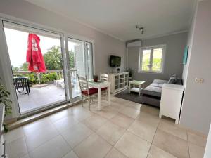 a room with a living room with a table and a couch at Apartments Ruzic Njivice in Njivice