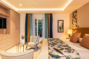 Hotel Byblos Saint-Tropez في سانت تروبيز: غرفة الفندق بسرير وطاولة