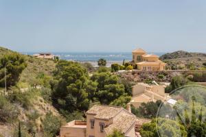 a house on the hill with the ocean in the background at La Manga Club Resort - Buena Vista 596 in Atamaría