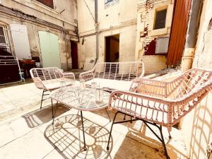 eine Gruppe von Stühlen und Tischen auf einer Straße in der Unterkunft Le Coeur De Nîmes in Nîmes