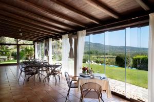 a dining room with tables and chairs and a large window at Villa Anastasia in Cugnana