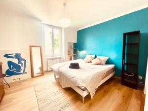 um quarto com uma cama grande e uma parede azul em Le Coeur De Nîmes em Nîmes