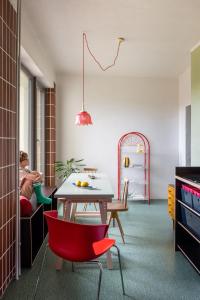 a living room with a table and red chairs at SOMTU design apartments in Liptovský Ján