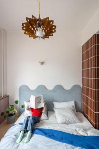 a girl laying on a bed with a box on her head at SOMTU design apartments in Liptovský Ján