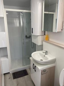 a white bathroom with a shower and a sink at Floating house ARENA 3 in Pula