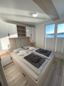 a large bed in a room with a large window at Floating house ARENA 3 in Pula