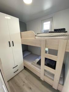普拉的住宿－Floating house ARENA 3，小房间设有一张双层床和白色橱柜