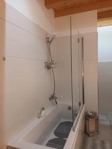 La salle de bains est pourvue d'une baignoire et d'une douche en verre. dans l'établissement Il melograno, à Vittorio Veneto