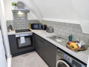 una pequeña cocina con fregadero y lavavajillas en City Centre Premier Top Floor Executive 2 Bed Apartment, en Sunderland