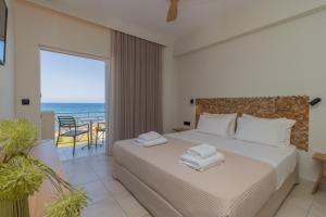 a bedroom with a bed and a view of the ocean at Artina in Marathopolis