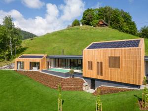 的住宿－steiRerBLiCke - Weingartenresidenz Guntschenberg，山顶上带太阳能电池板的房子