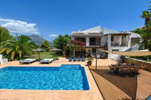 a villa with a swimming pool in front of a house at Bogira in Jávea