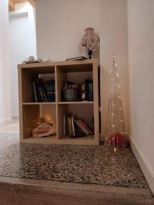 a book shelf with a christmas tree in a room at Il melograno in Vittorio Veneto