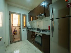 Il comprend une cuisine équipée d'un réfrigérateur et d'une cuisinière. dans l'établissement ALIYA LUXURY APARTMENT El HOUDA-AGADIR, à Agadir