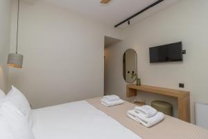 a bedroom with a bed and a tv and towels at Artina in Marathopoli