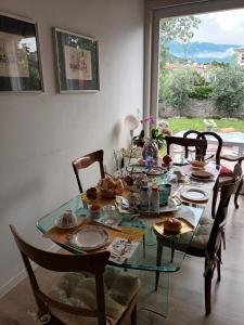 - une table à manger avec des chaises et une table en verre dans l'établissement Il melograno, à Vittorio Veneto