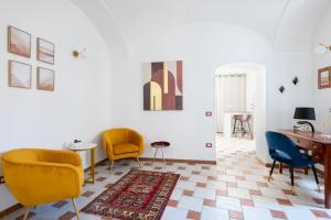 a living room with yellow chairs and a table at Don Pedro 53 in Tresnuraghes