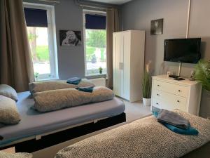 a living room with two beds and a television at Stadtnah an der Förde 51 HH in Flensburg