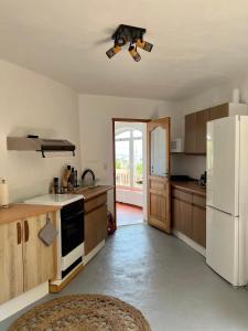 uma cozinha com armários de madeira e um frigorífico branco em Guest suite in Calpe Maryvilla amazing view em Calpe