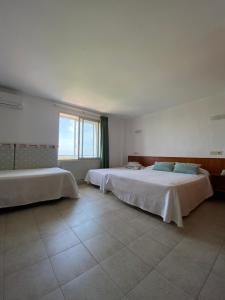 1 dormitorio con 2 camas y ventana grande en Hostal Blayet, en Valencia