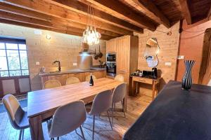 une cuisine avec une grande table et des chaises en bois dans l'établissement RIBERA 1 - Beautiful reformed house PARKING, à Formiguères