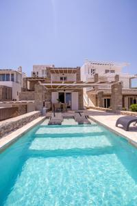 a pool with blue water in front of a house at Nuera Villa in Mýkonos City