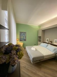 a bedroom with a bed and a green wall at Strandhaus San Sebastiano in Spotorno