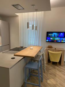una cucina e una sala da pranzo con tavolo e TV di Strandhaus San Sebastiano a Spotorno