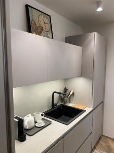 a kitchen with a sink and a clock on the wall at Strandhaus San Sebastiano in Spotorno