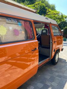 una furgoneta naranja estacionada con la puerta abierta en Chambres chez Nanou avec petit déjeuner en Chimay