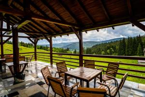 a patio with tables and chairs and a view of the mountains at Pensiunea Romconcord in Bălceşti
