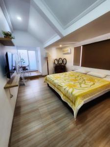 a bedroom with a large bed with a yellow blanket at Kulem Gempol in Bandung
