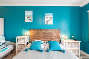 een slaapkamer met blauwe muren en een bed met blauwe kussens bij Villa Cordouan in Saint-Palais-sur-Mer