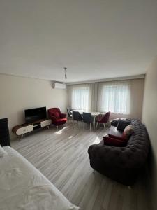 a living room with a couch and chairs and a television at Abbasi Apart in Bursa