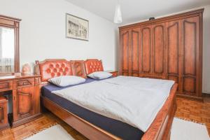 a bedroom with a wooden bed and a wooden dresser at Holiday House Radovna Bled in Zgornje Gorje