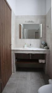 un baño con lavabo y espejo en Heliophilia Malona, en Malona Village