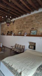Un dormitorio con una cama y una pared de piedra. en Heliophilia Malona, en Malona Village