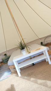 Carrowmena Family Glamping Site & Activity Centre في ليمافادي: سرير في خيمة عليها زرع