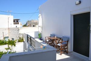 a balcony with a table and chairs on a building at Cute Studio in Milos in Tripití