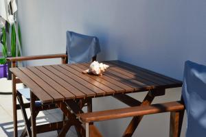 Cute Studio in Milos في تريبيتي: طاولة خشبية مع كرسيين ازرق وطاولة خشبية